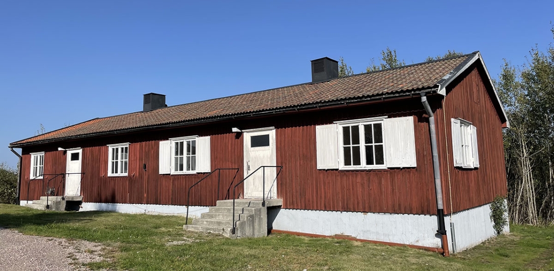 Red wooden house with white doors